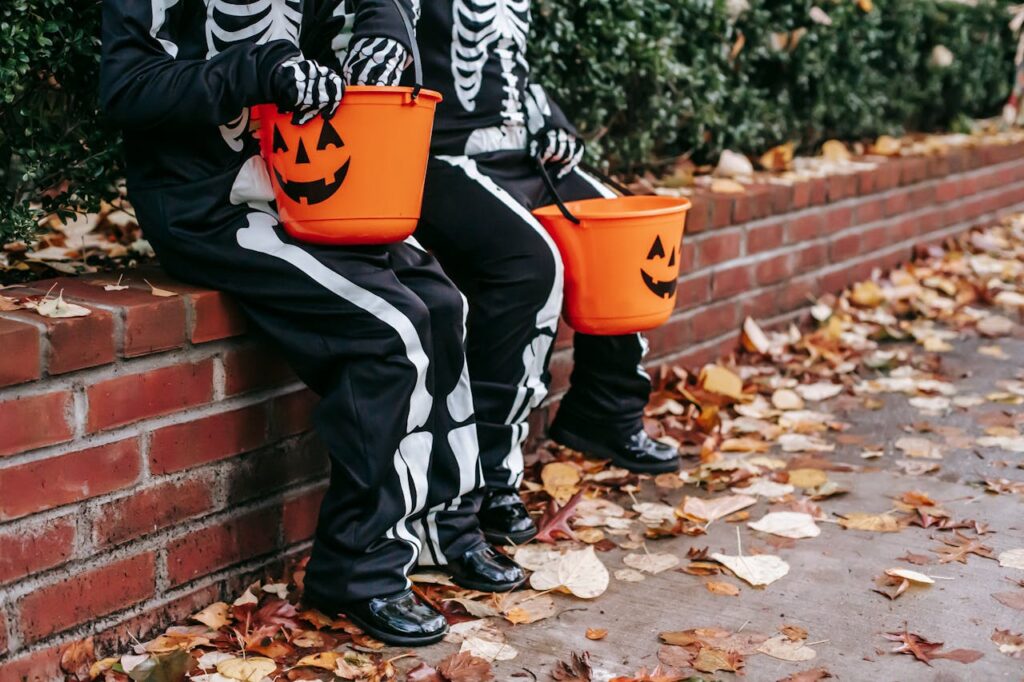 Kids in Halloween costumes sitting on a brick fence